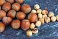 Top view of a group of whole and peeled hazelnuts on blue marble background in horizontal