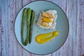 Top view of hake fillet with mango sauce and asparagus. Plate with warm colours and yellow background. Seafood dish