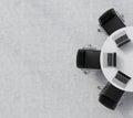 Top view of a half of the conference room. A white round table, three black leather chairs. Three laptops are on the table.