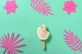 half eaten red jujube and milk flavor popsicle with paper cutting flowers and leaves on green background