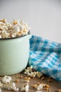 Top view of half a pot with freshly made popcorn on rustic wooden table with blue cloth, white background Royalty Free Stock Photo