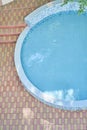 Top view of a half round outdoor swimming pool with blue mosaic ceramic tiles, with blue clear water. Background with Royalty Free Stock Photo