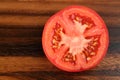 Top view of half tomato on wooden background. sliced tomato