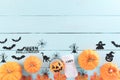 Top view of Halloween crafts, orange pumpkin, ghost, bat and spider on green pastel wooden background with copy space for text. Royalty Free Stock Photo