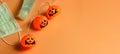 Halloween pumpkin lights, medical mask and alcohol sanitizer gel on orange background. Halloween , COVID-19 prevention and new Royalty Free Stock Photo