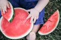 Top view of halved watermelon and slices on sitting baby& x27;s feet Royalty Free Stock Photo