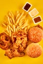 Top view hamburger, french fries and fried chicken on yellow background. Copy space for your text.