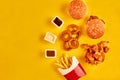 Top view hamburger, french fries and fried chicken on yellow background. Copy space for your text.