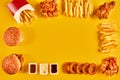 Top view hamburger, french fries and fried chicken on yellow background. Copy space for your text.