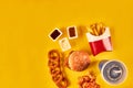 Top view hamburger, french fries and fried chicken on yellow background. Copy space for your text.