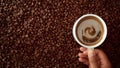 Top view of hand with cup of black coffe put it on coffe beans background Royalty Free Stock Photo