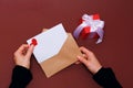 Top view. Hand of girl writing love letter on Saint Valentines Day. Handmade postcard with red heart shaped figure. 14 February Royalty Free Stock Photo