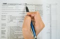 Top view of hand hold pen fill in the details on the tax forms paper in business concept. Royalty Free Stock Photo