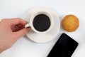 Top view, Hand holding of a espresso coffee in white cup with brownie muffin cakes and smartphone isolated on white background, Royalty Free Stock Photo