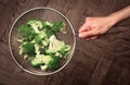 Top view of a hand holding a strainer with cut broccoli Royalty Free Stock Photo