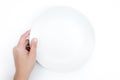 Top view, hand holding a white plate on a white background, Close up. Isolated background Royalty Free Stock Photo