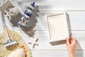 Top view hand lying summer rustic picture frame and lighthouse,seashell decorate on white wooden table with sunlight shade Royalty Free Stock Photo