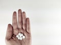 Top view of a hand palm holding many white drug pills tablets on white background as painkillers for pain Royalty Free Stock Photo