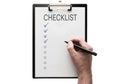 Top view of hand with pen on clipboard with checklist on white background