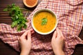 top view of hand placing napkin beside lentil soup