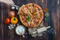 Top view of hand-scoop seafood pizzas and ingredients with garnish on a wooden floor. Royalty Free Stock Photo