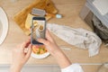 Top view of hand with smartphone taking photo of plate with pasta with tomato sauce for culinary blog Royalty Free Stock Photo