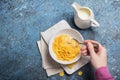 Tasty breakfast of sweet cornflakes in milk and hand with spoon Royalty Free Stock Photo