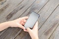 Top view hand using phone blank screen on wooden table