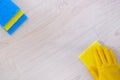 Top view. Hand in yellow rubber protective glove cleaning parquet floor with rag at home. Housework and housekeeping concept Royalty Free Stock Photo