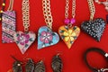 Top view of handcrafted decorative wooden hearts on chains with a red background