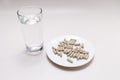 Top View Handful Of Pills, Capsules OF Slippery Elm And Glass Of Water on Table. Dietary