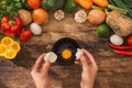 Top view of hands holding egg shell with egg yolk separated