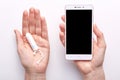 Top view of hands holding smartphone with blank screen and tampon, online women calendar for critical days, menstruation time,