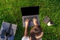 Top view. Woman working on laptop pc computer with blank black empty screen to copy space in park on green grass Royalty Free Stock Photo