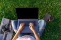 Top view. Woman working on laptop pc computer with blank black empty screen to copy space in park on green grass Royalty Free Stock Photo