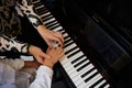 Top view hands of musician pianist teacher maestro teaching a child boy the true position of fingers on piano keys while Royalty Free Stock Photo