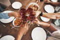 Top view, hands and toast with red wine at dinner table for new year celebration in home. Party, cheers and group of