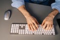 Top view of hands of unrecognizable man using wireless keyboard and computer mouse at dark room. Royalty Free Stock Photo