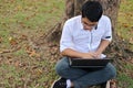 Top view of handsome asian young man working against laptop computer in outdoor park. Royalty Free Stock Photo