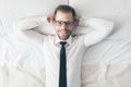 Top view. Handsome businessman with glasses lying on bed Royalty Free Stock Photo