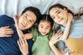 Top view of Happy Asian beautiful young mother, father and their daughter looking at camera and smiling while lying on bed Royalty Free Stock Photo