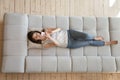 Top view beautiful young woman using phone, relaxing on couch Royalty Free Stock Photo