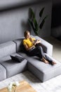 Top view happy beautiful young woman using phone, relaxing on couch at home Royalty Free Stock Photo