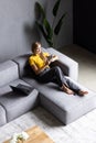 Top view happy beautiful young woman using phone, relaxing on couch at home Royalty Free Stock Photo