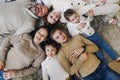 Top view of happy big multi-generation family lying in circle on floor and smiling at camera Royalty Free Stock Photo