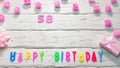 Top view of happy birthday 58 candle letters for a girl in pink shades with beautiful rose flowers, postcard congratulation copy Royalty Free Stock Photo