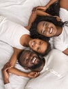 Top view of happy black family lying in bed together Royalty Free Stock Photo
