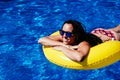 Top view of happy caucasian woman relaxing on yellow donuts inflatable at swimming pool. Summer time, vacation and lifestyle Royalty Free Stock Photo