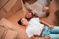 Top view, happy couple and moving into new home on floor, ground and relax from packing boxes. Man, woman and taking a Royalty Free Stock Photo