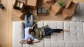 Top view happy couple relaxing on couch after relocation